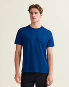 man wears a blue merino t-shirt with short sleeves with crew neck in 17,5 micron merino yarn
