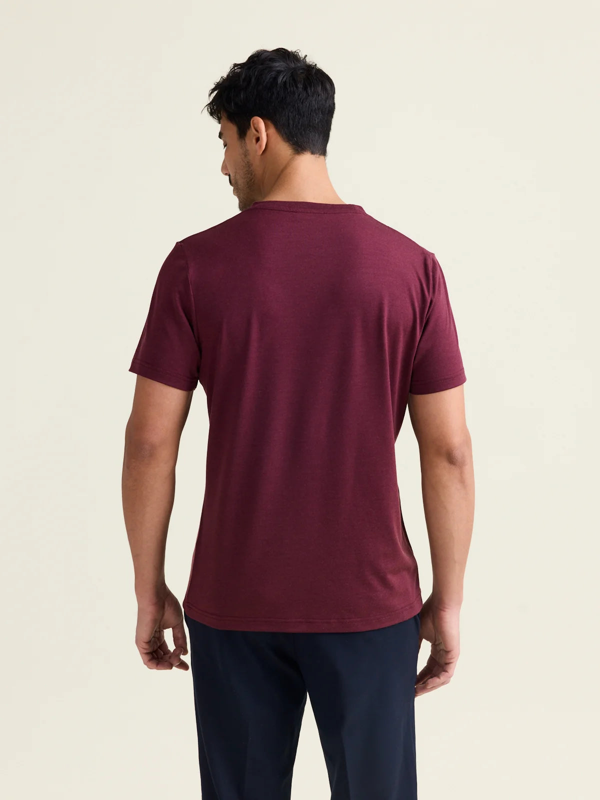 Rear perspective of Wolk's burgundy merino wool T-shirt for men, showcasing the clean back design.