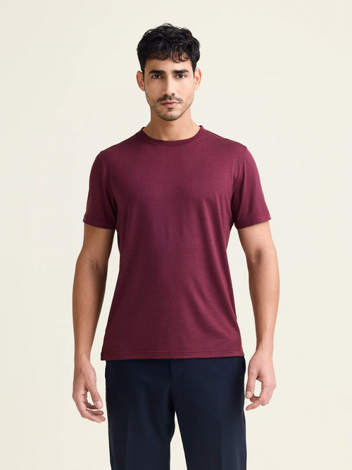 Man wears burgundy merino wool T-shirt with crew neck and short sleeves from Wolk.
