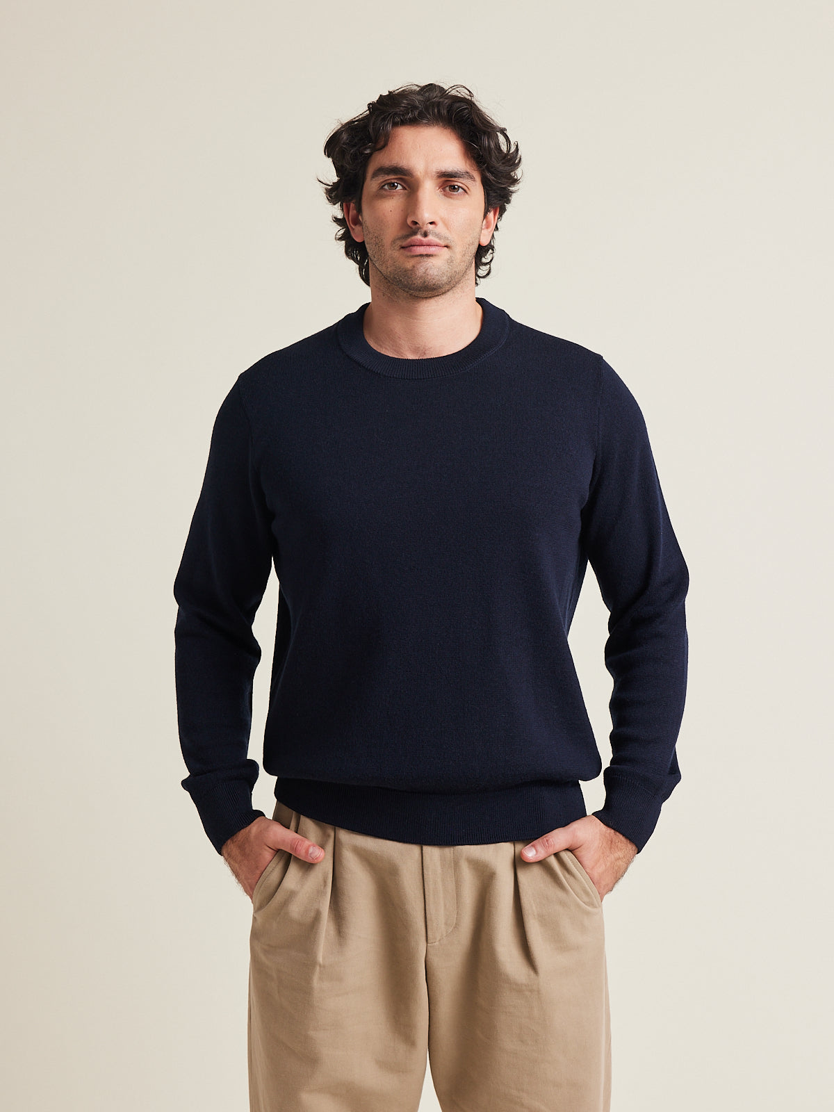 Man wears a 100% merino wool sweater pullover in dark navy with round collar and mid weight from Wolk made in Portugal