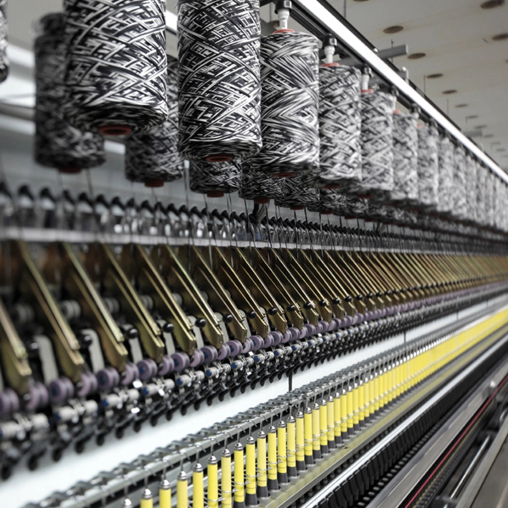 Spools of yarn on a textile machine in a factory setting