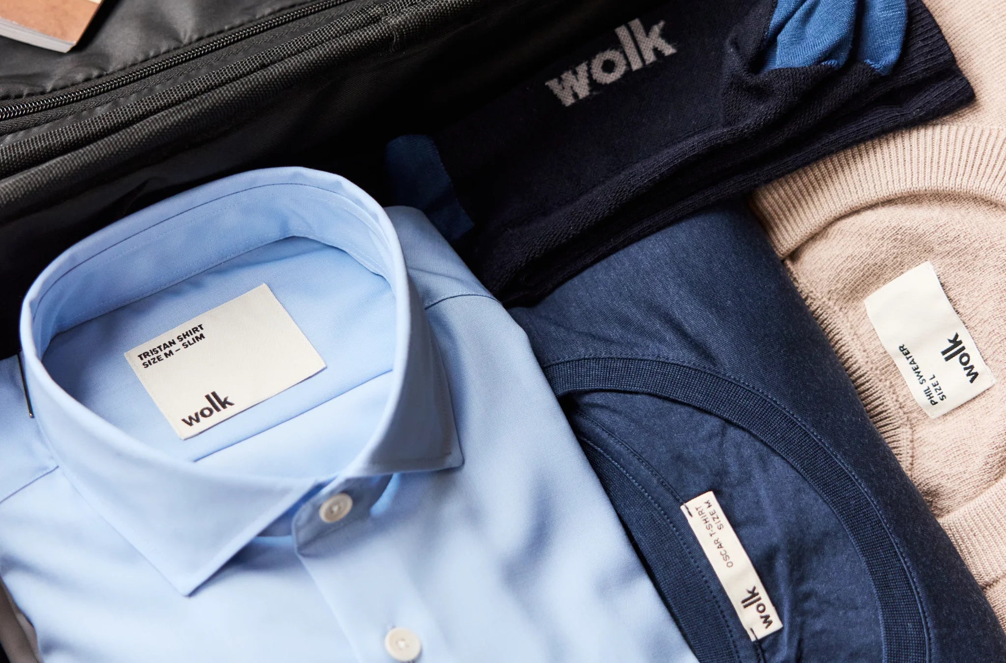 Folded shirt, T-shirt, sweater and socks in merino wool packed in suitcase