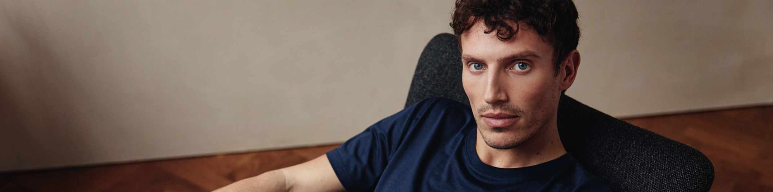 Navy Merino T-shirt top banner on male model seated in chair