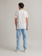 Backside view of model wearing a White merino T-shirt in studio