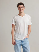 Man wears a white merino wool and nylon blend T-shirt with Vneck and short sleeves from Wolk