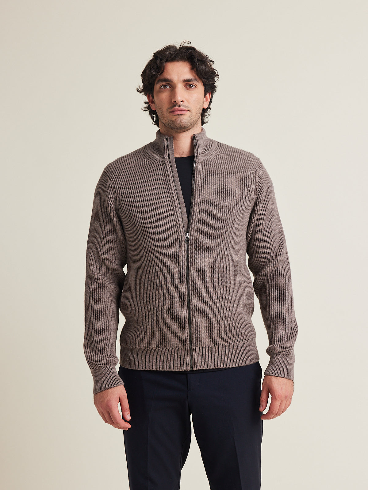 Man wears a haf zip merino wool sweater. in heavy weight warm with side pockets and high collar in brown color made in Portugal