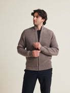 Man wears a haf zip merino wool sweater. in heavy weight warm with side pockets and high collar in brown color made in Portugal with 100% responsible merino wool