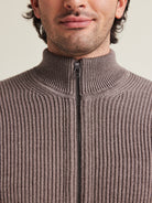 Close up of high collar zipped sweater in brown color and cardigan knit structure from Wolk