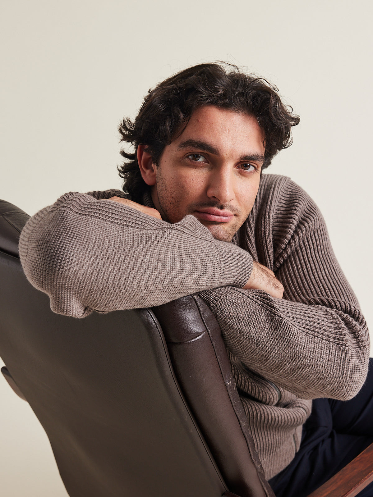 Man wears a merino wool full zip cardigan with reïnforced elbows and high collar in brown color winter warm