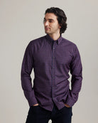 Man wearing a burgundy checkered merino button-down shirt against a plain background