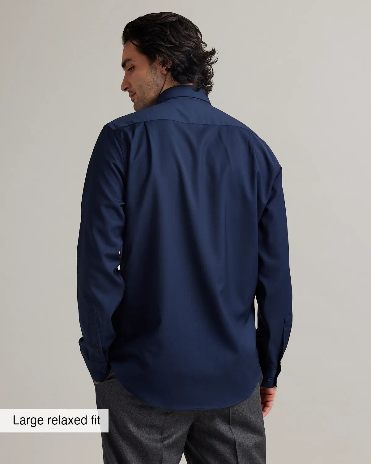 Man wearing a navy blue dress shirt with text 'Large relaxed fit' on a plain background