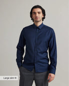 Man wearing a navy blue merinowool shirt in slim fit with a gray background