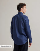 back view of a model wearing a navy blue merino shirt with graph check pattern and button down collar