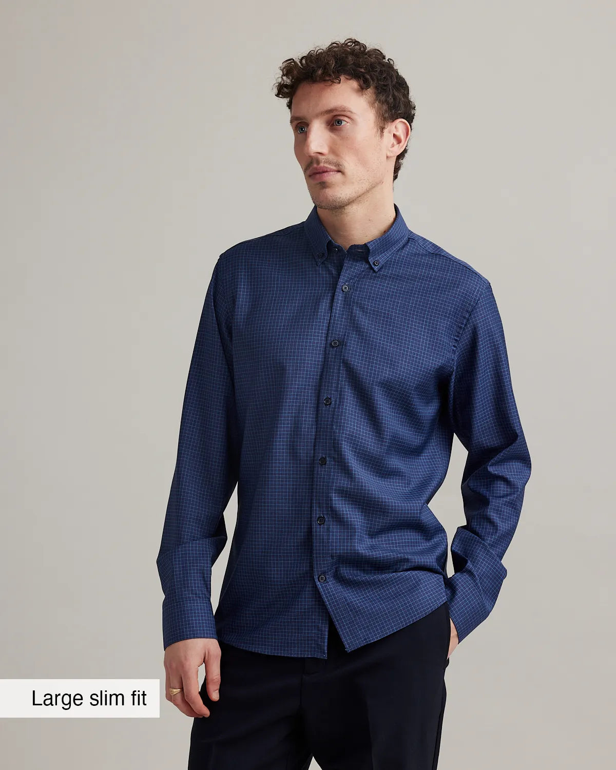 Man wearing a navy blue merino shirt with graph check pattern and button down collar in slim fit