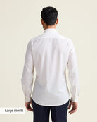Man wearing a white merino dress shirt with in slim fit showing the untucked back of the shirt