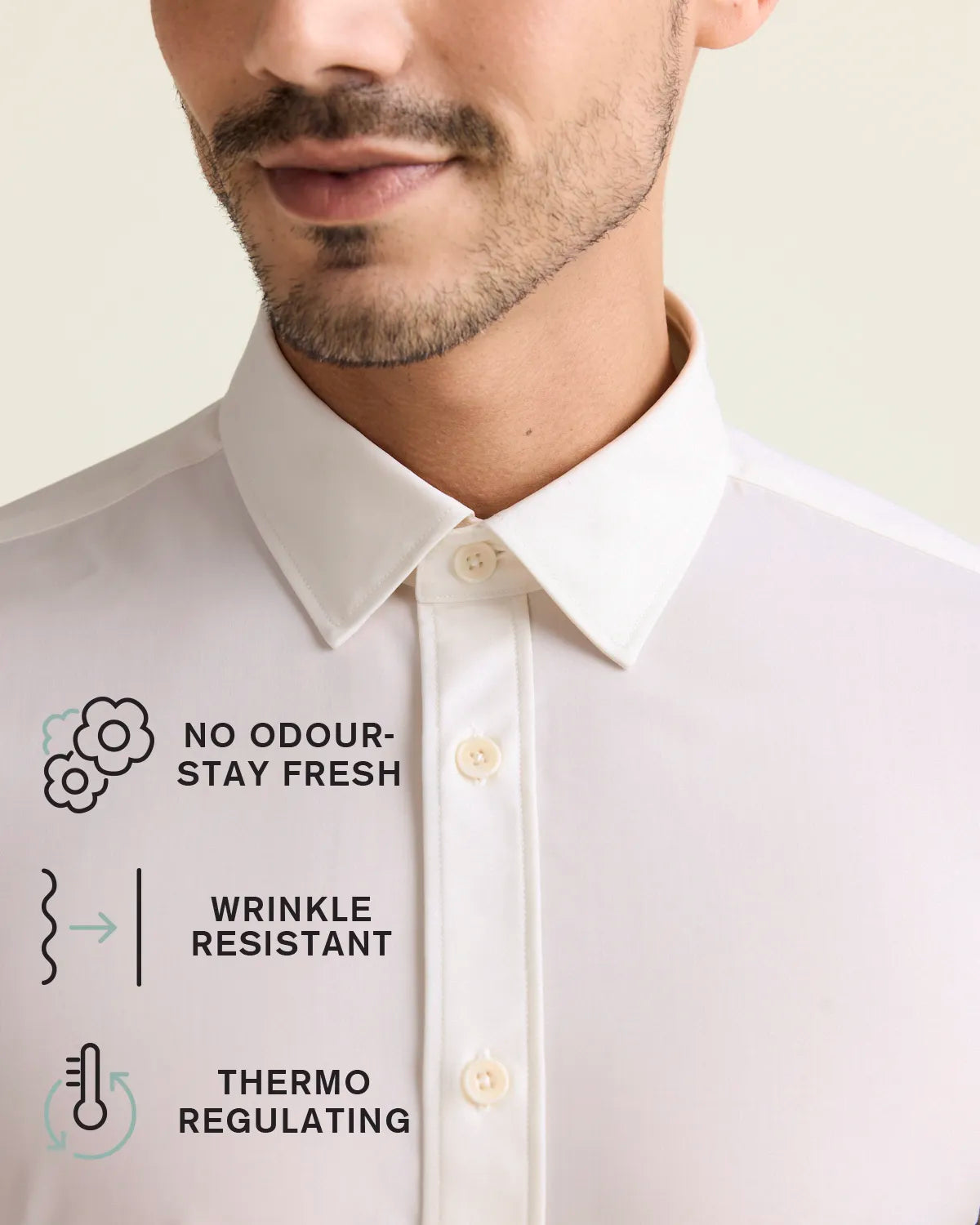 Collar detail of a white merino wool dress shirt with icons indicating no odour-stay fresh, wrinkle resistant and thermo-regulating