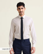 Man wearing a white merinowool dress shirt from in slim fit with navy trousers and a black tie on a beige background