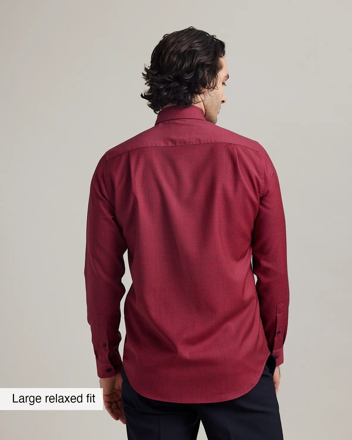 Back view of a man wearing a red merino long sleeve dress shirt with text 'Large relaxed fit' on a plain background