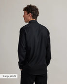 Man wearing a black merino shirt with text 'Large slim fit' on a plain background