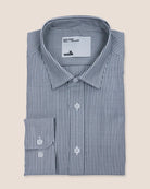 Folded blue and white bengal striped merino shirt with 'wolk' label on a beige background