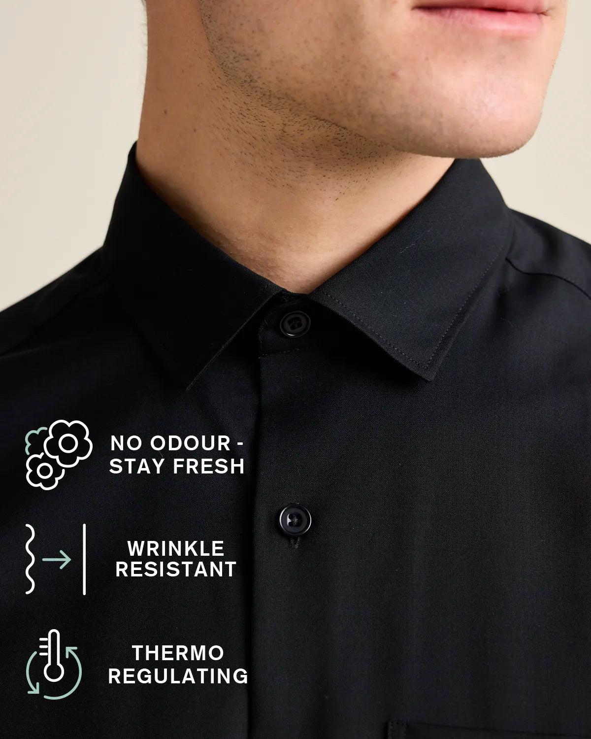 Black merino shirt with text and icons indicating features like no odour, wrinkle resistance, and thermo regulation.