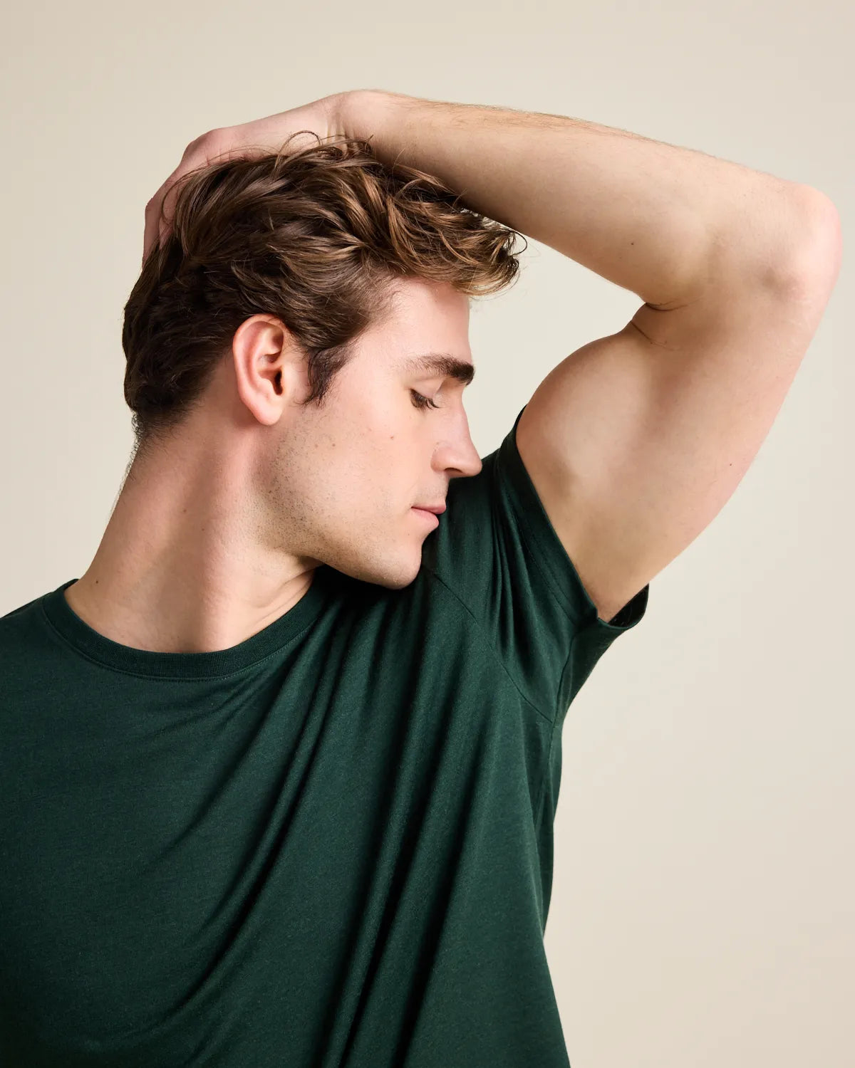 model smelling his armpit in a dark green merinowool T-shirt from Wolk