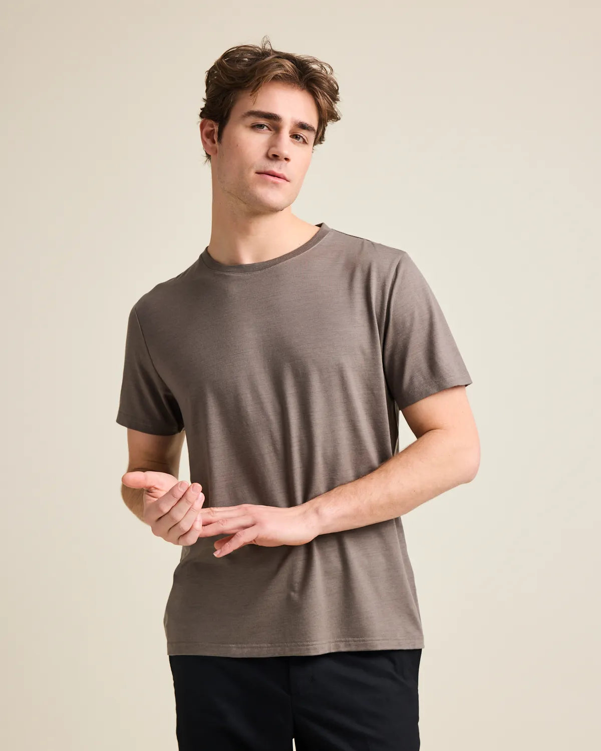 Male model wearing a brown merino t-shirt against a beige background