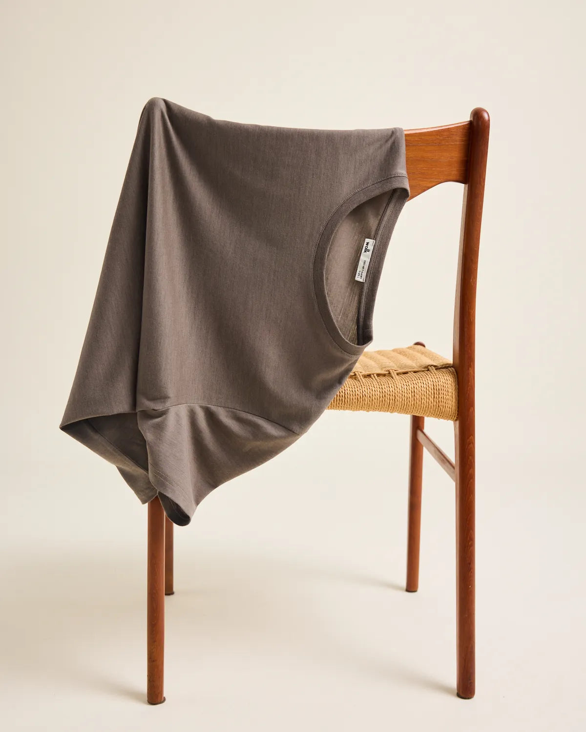a brown merino T-shirt draped over a wooden chair