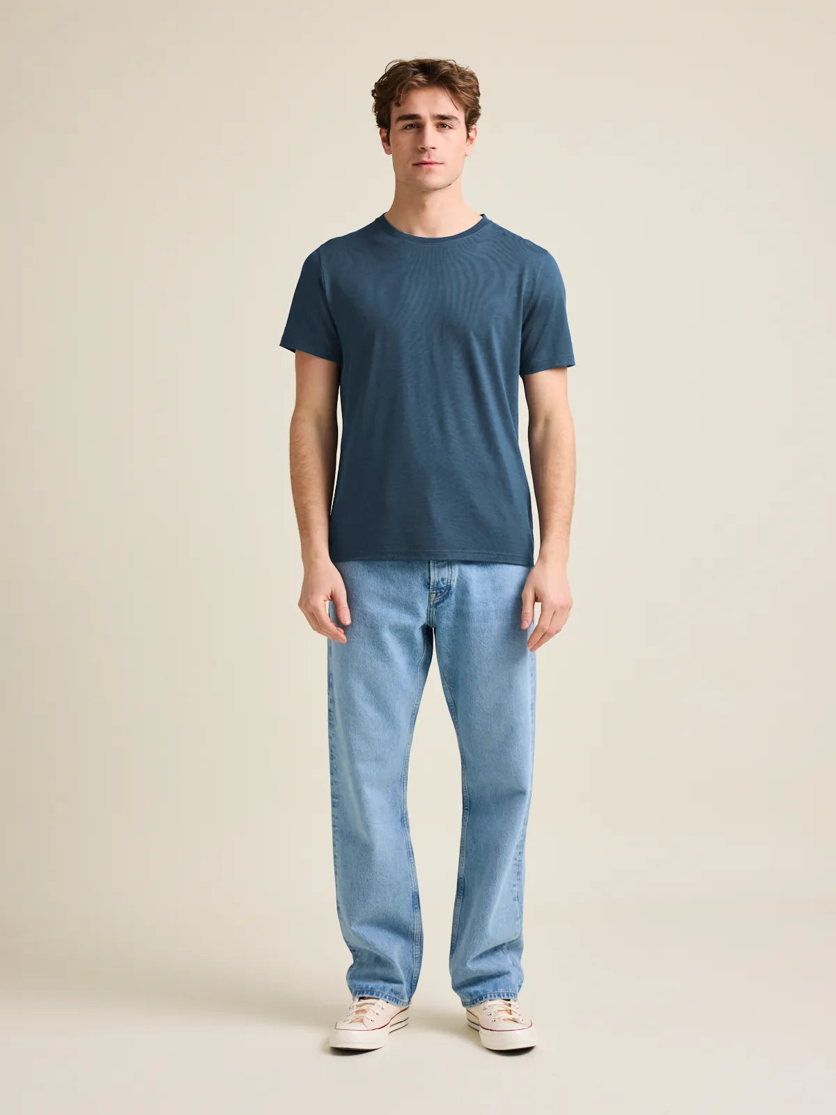 Wolk's denim blue men's merino wool T-shirt in a studio setting, showcasing crew-neck design and short sleeves