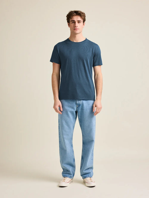 Wolk's denim blue men's merino wool T-shirt in a studio setting, showcasing crew-neck design and short sleeves