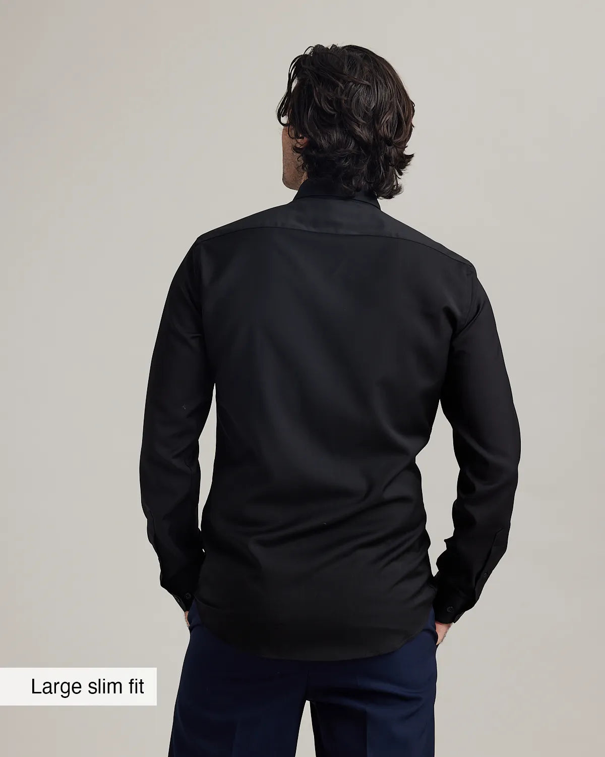 Back view of a person wearing a black merinowool formal shirt with text 'Large slim fit' on a plain background
