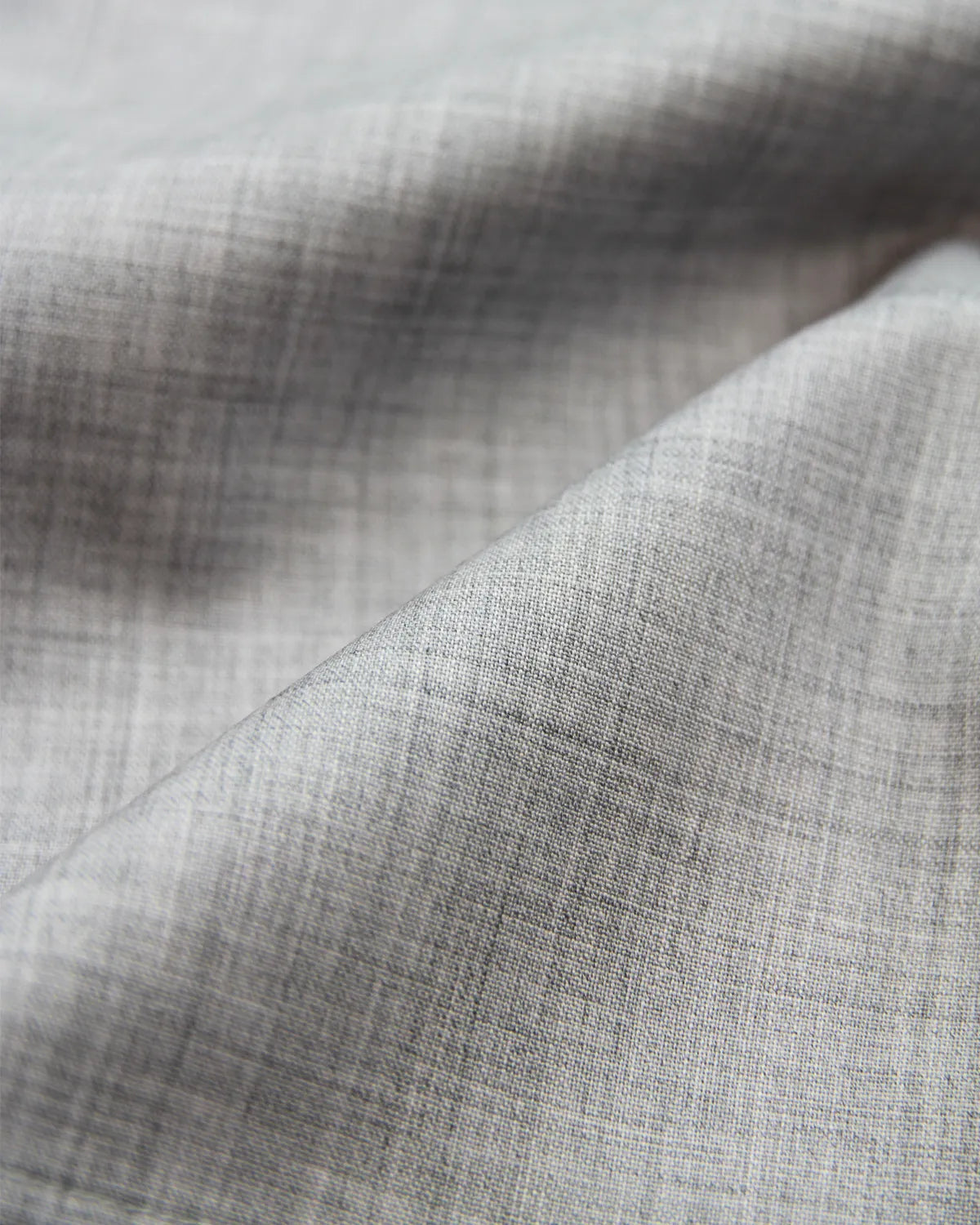Close-up of gray woven merino wool fabric with a subtle heather pattern