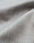 Close-up of gray woven merino wool fabric with a subtle heather pattern