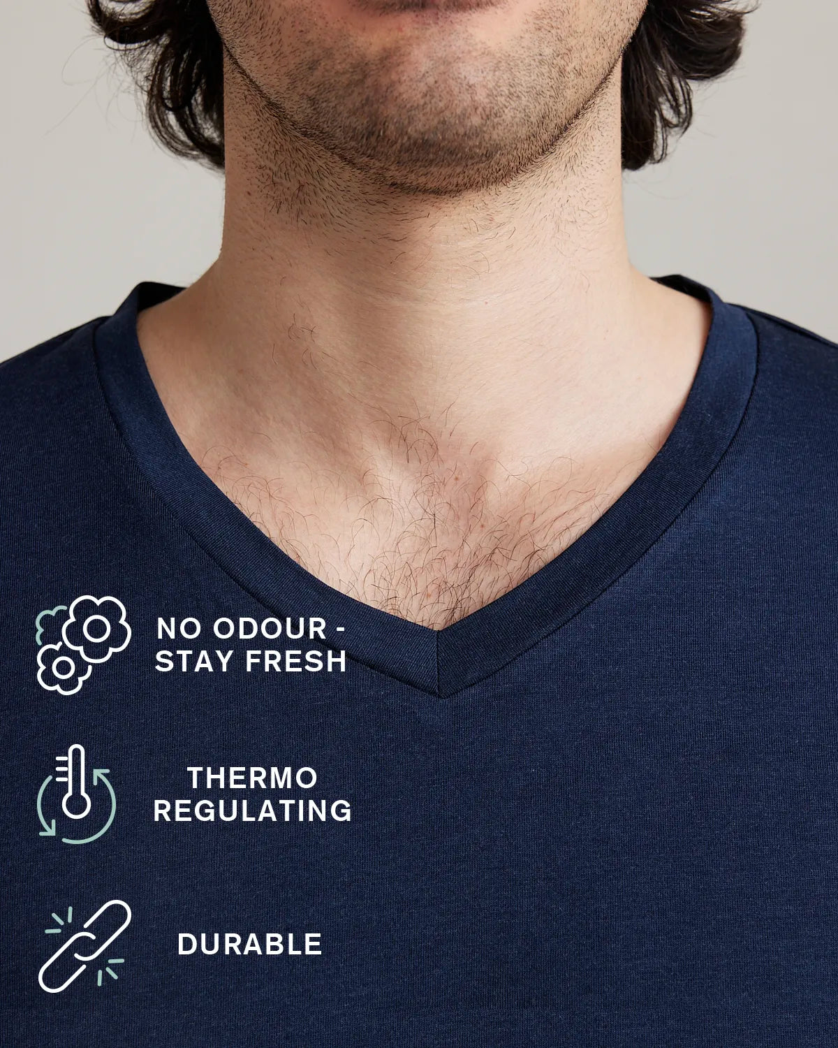 Collar detail of a Navy blue V-neck Tshirt with icons displaying the odour resistance, thermo-regulation and durability of Wolk merino Tshirts 