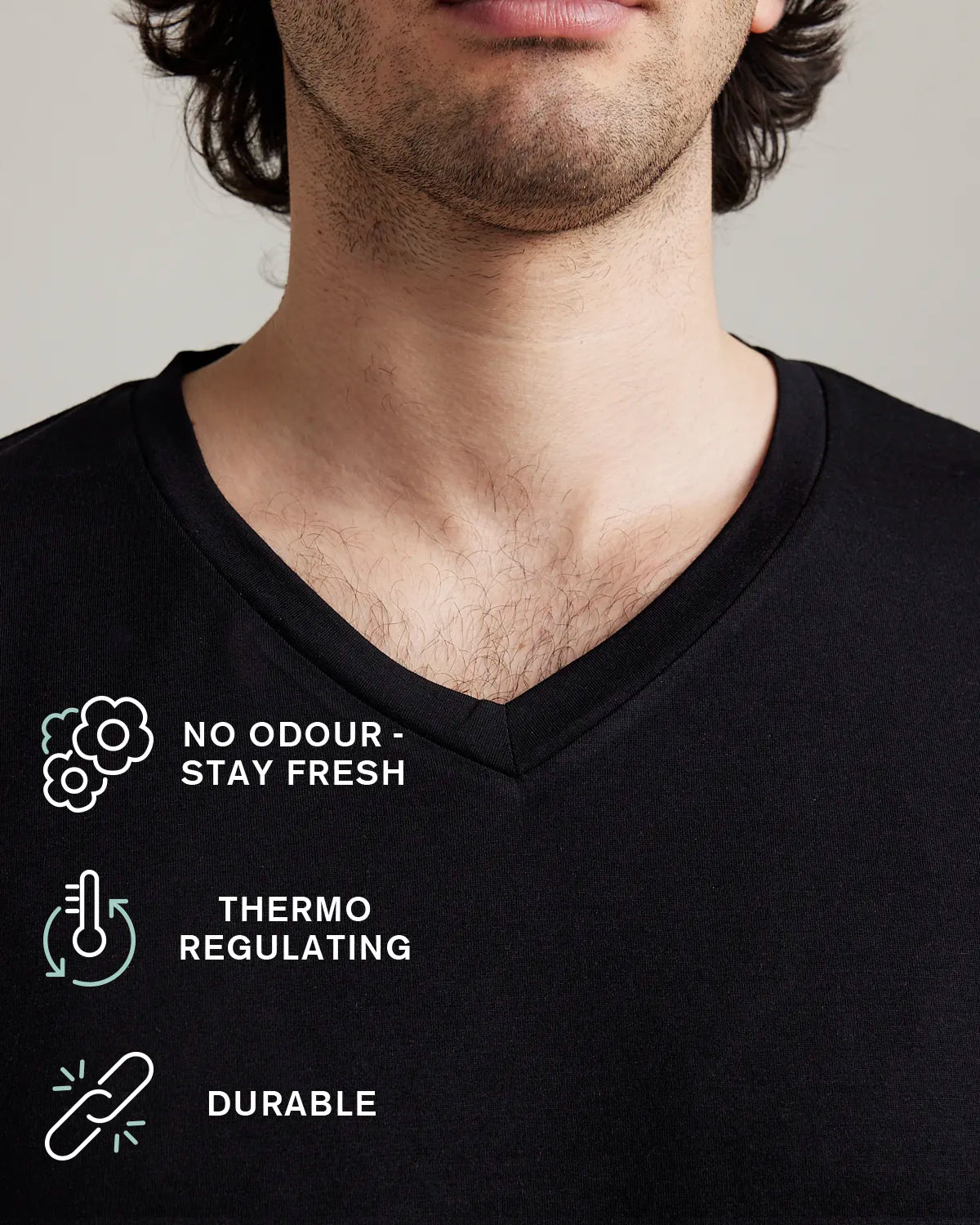 Black V-neck merino wool T-shirt with text indicating features like no odor, thermo regulating, and durable on a neutral background.