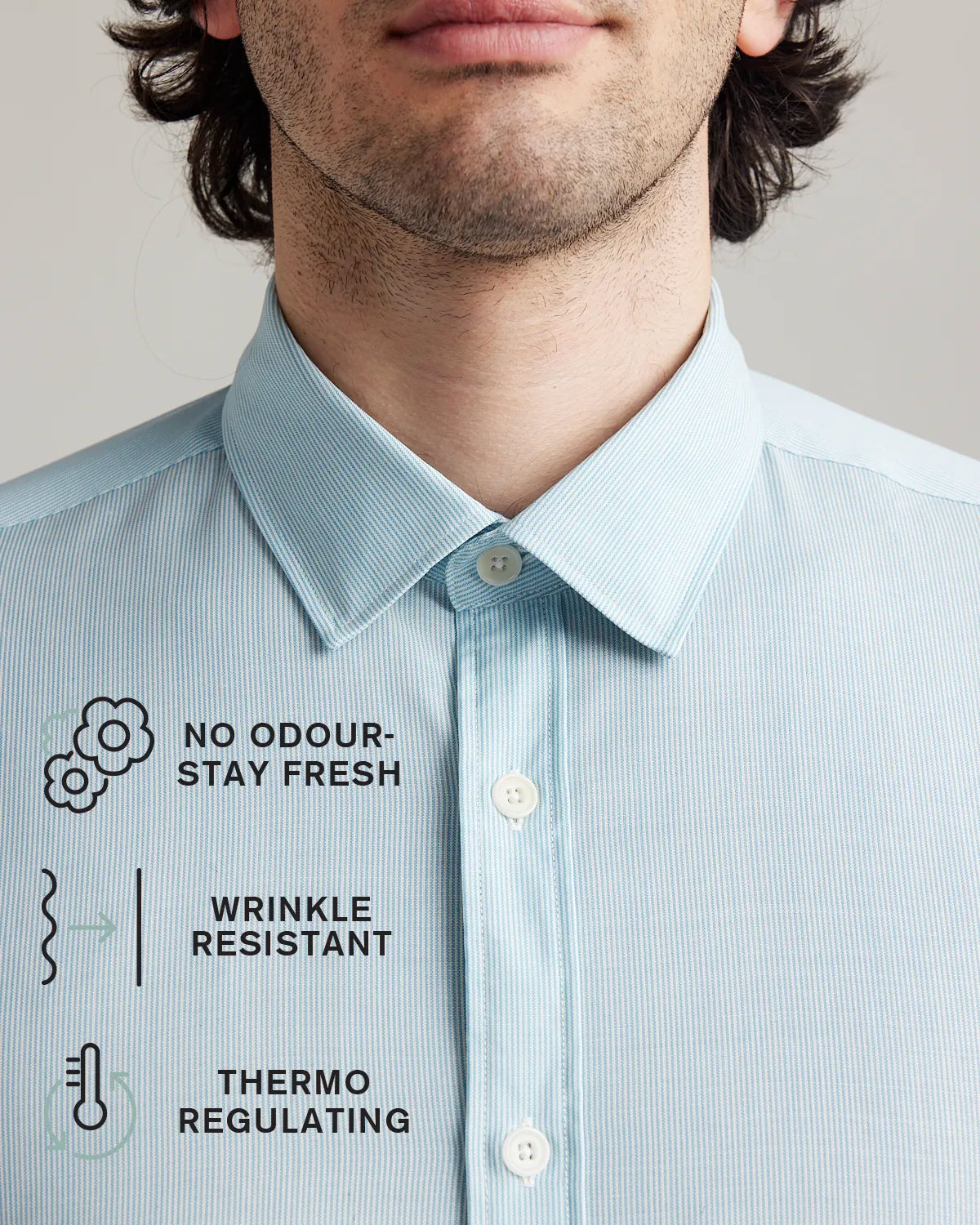 collar detail of a light blue hairline striped merino dress shirt with icons explaining no odour-stay fresh, wrinkle resistant and thermo-regulating