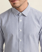 Close-up of a man wearing a merinowool dress shirt in a navy bengal stripe pattern highlighting the collar and buttons