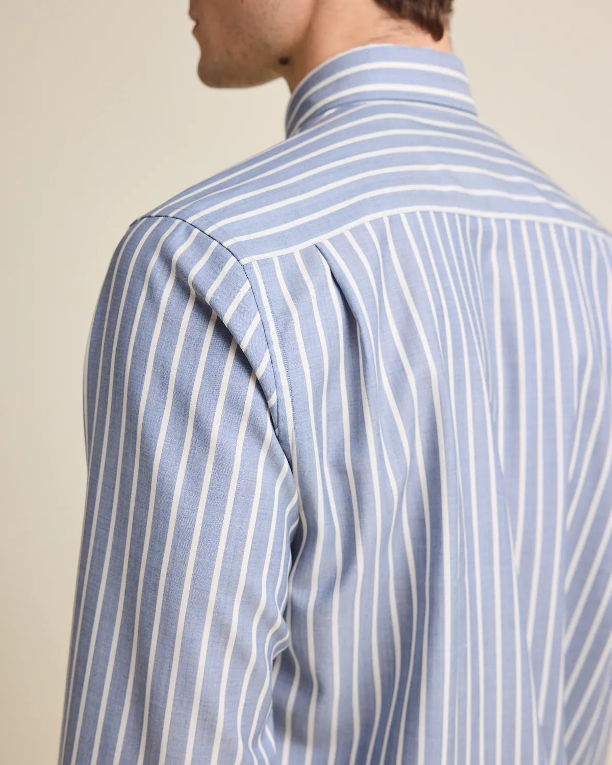 Back pleat on a navy blue and white striped merino wool button up shirt 