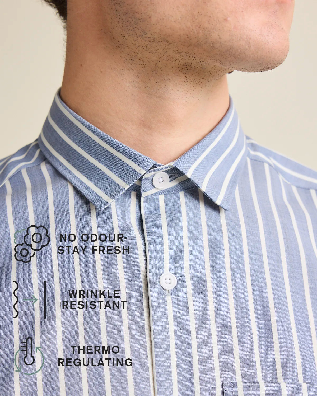 collar of a navy blue and white striped merino button up shirt with icons explaining no odour-stay fresh, wrnkle resistant and hermo-regulating