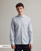 Man wearing a light blue merino wool shirt with text 'Large slim fit' on a gray background