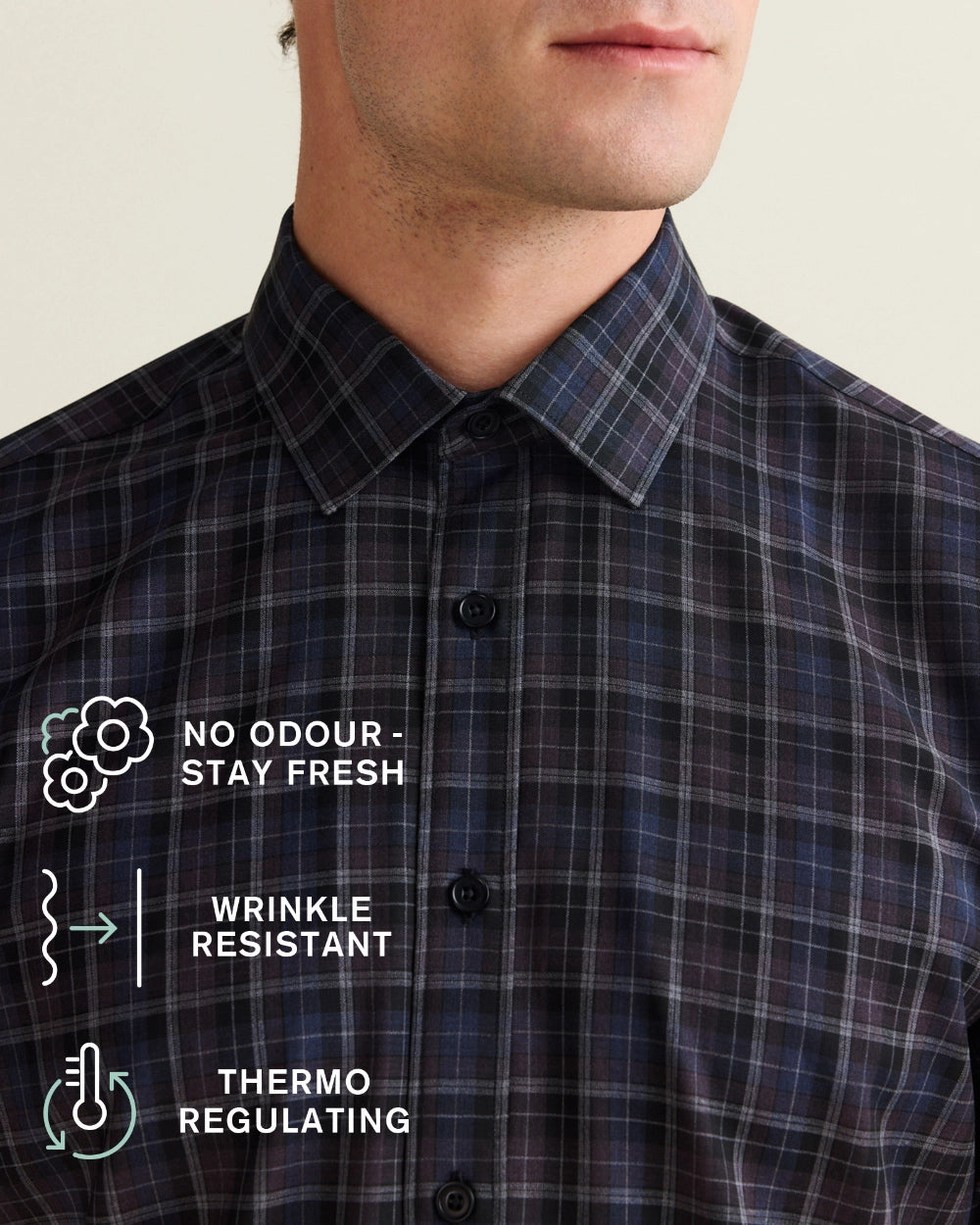 Close-up of a man wearing a dark navy and black, purple plaid merino shirt, with white text overlays highlighting features like 'No Odour, Stay Fresh', 'Wrinkle Resistant', and 'Thermo Regulating'.