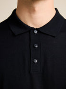 Detail of the collar on the black men's merino polo from the European brand Wolk.