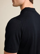 Shoulder detail of a men's black merino wool Polo shirt from Wolk, emphasizing the luxurious Cashwool knit.