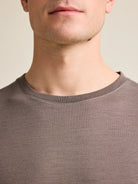 Detail shot of the chocolate brown crew neck collar from Wolk's men's merino wool T-shirt collection.