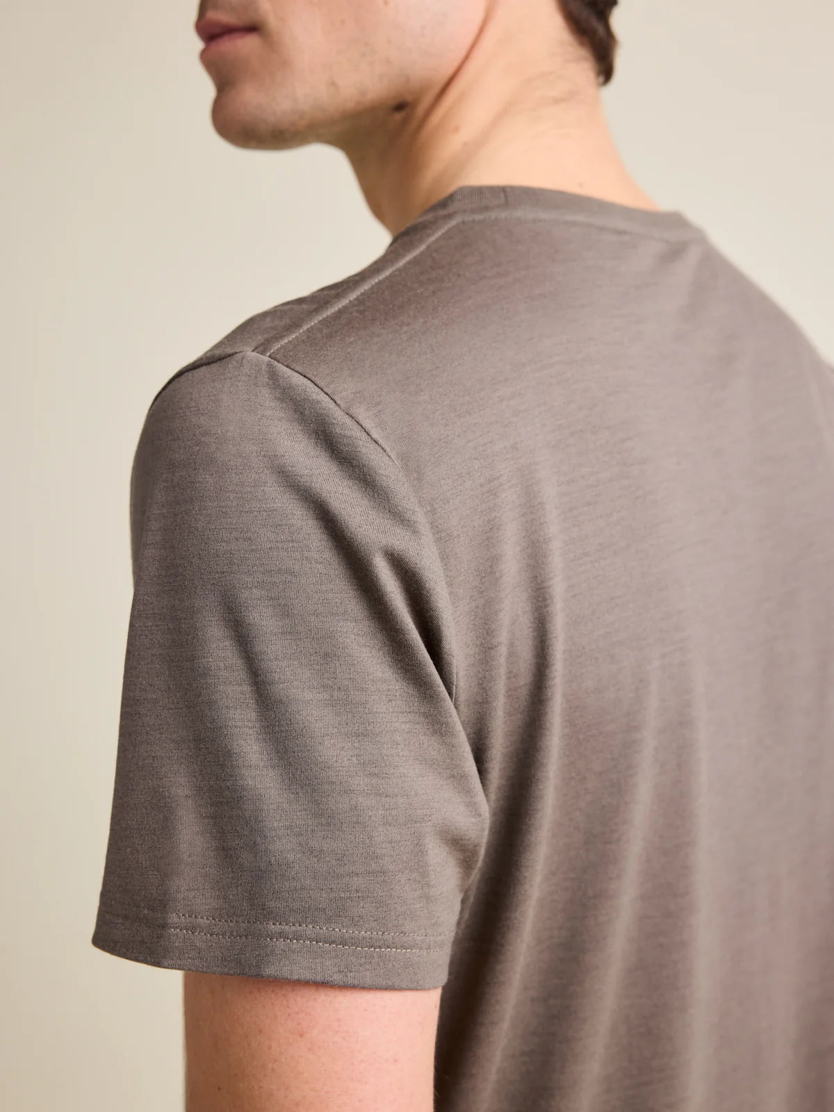 Close-up of the shoulder seam on Wolk's chocolate brown merino wool T-shirt for men.