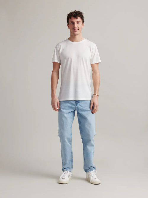 Studio shot of a men's white merino wool T-shirt from Wolk, displaying the front profile and sleek design.