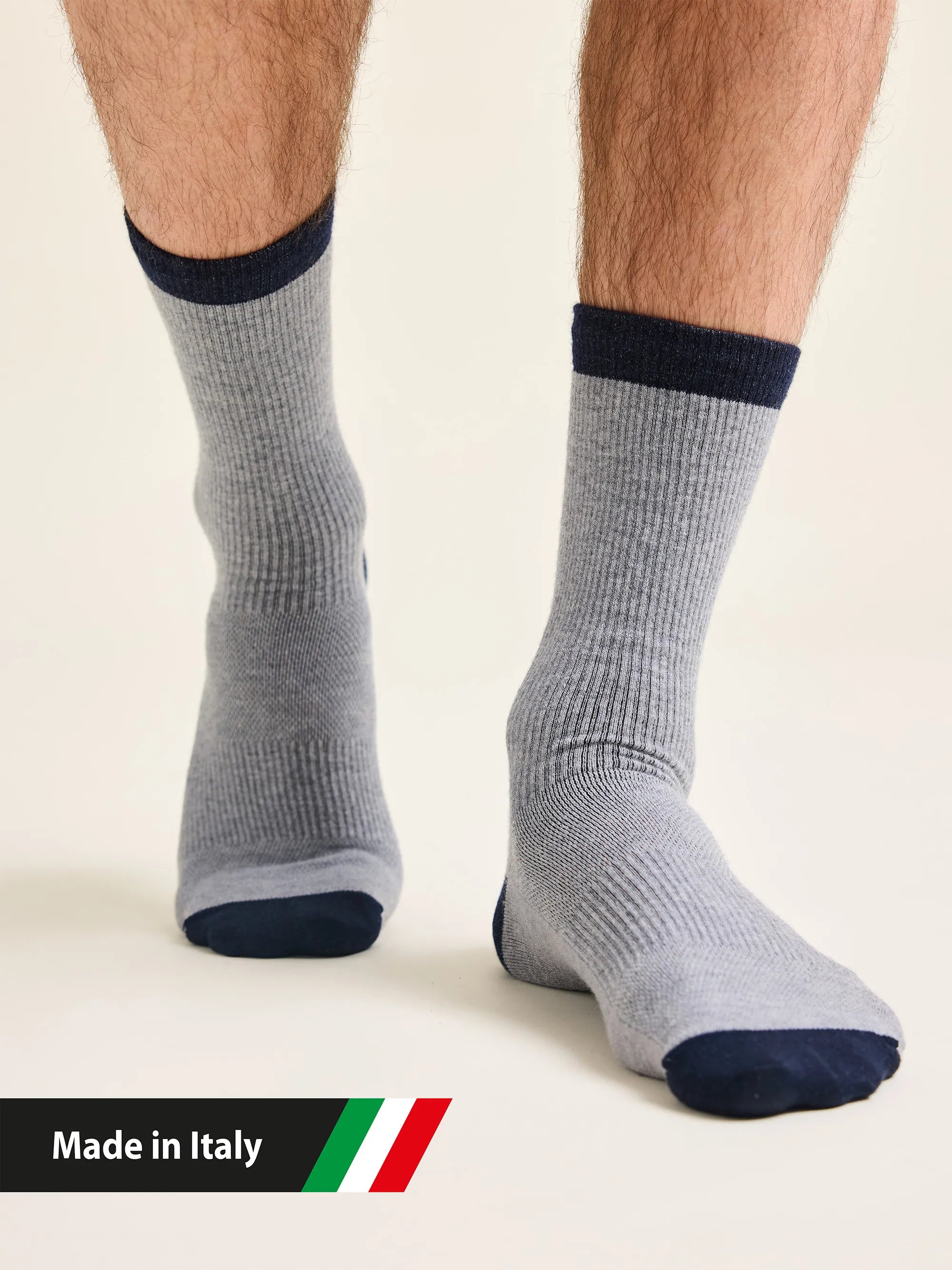 Gray merino wool socks with navy accents worn by a man , with 'Made in Italy' text and flag.