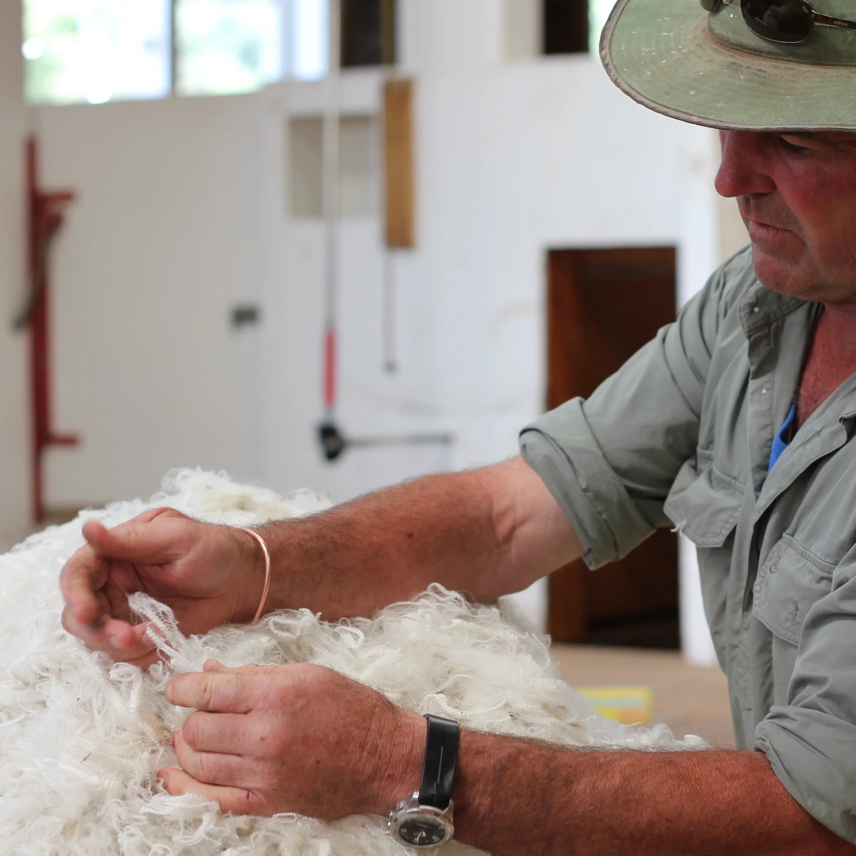 Man checking and selecting merino wool fibers in a workshop setting