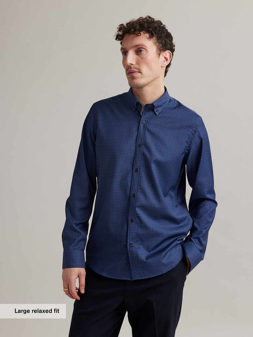 man wearing merino shirt on bike in blue color with small graph check and button down collar in relaxed fit from Wolk