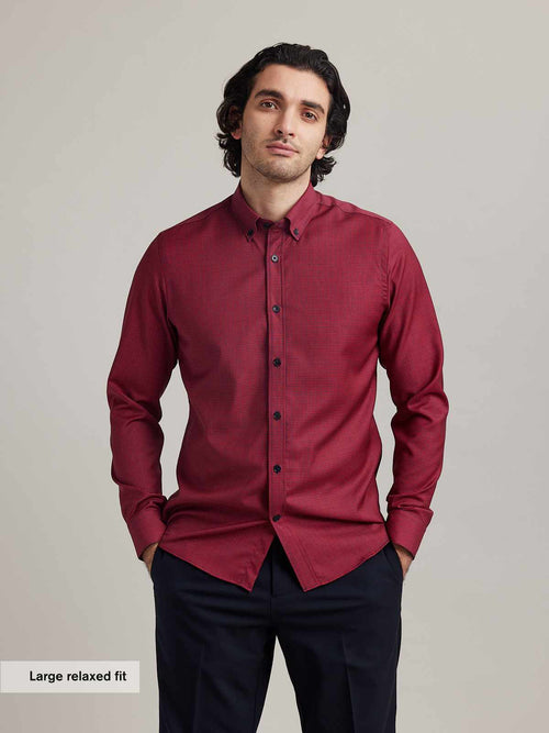 Men wears a merino wool shirt from wolk on red navy mini gingham with button down collar and navy buttons in relexed fit and long sleeves
